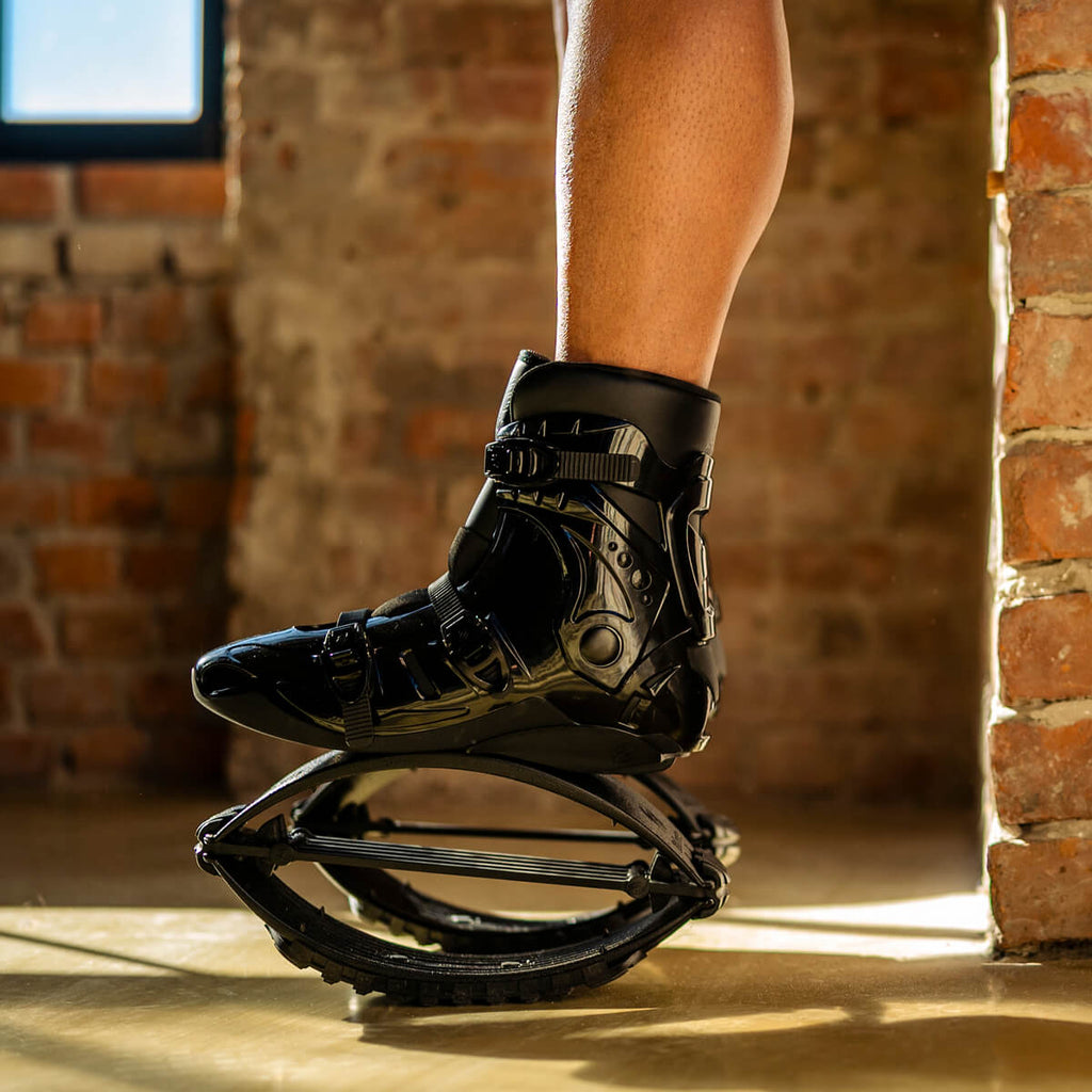 Vista lateral em grande plano de uma pessoa de pé enquanto usa Fit Boots Rebound Boots em espaços interiores.